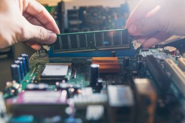 Teknisyen RAM 'i ana bilgisayarın prizine yerleştiriyor. Bilgisayar donanımı, teknisyen, endüstriyel ve elektronik kavramı