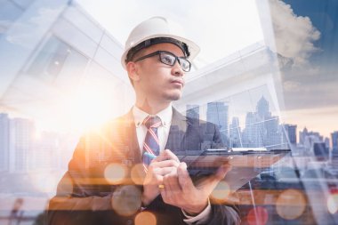 Gündoğumu sırasında kentin görüntüsüyle örtüşen mühendisin çift pozlama görüntüsü. Mühendislik, inşaat, şehir hayatı ve gelecek kavramı..