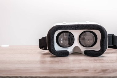 Tahta masadaki VR gözlüklerinin soyut görüntüsü. İletişim, oyun, internet ve gelecekteki yaşam kavramı..