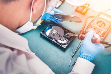 Teknisyenin masasındaki sabit diskin içindeki soyut görüntü ve bir bilgisayar anakart bileşeni. Veri, donanım ve bilgi teknolojisi kavramı