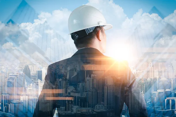 Gündoğumu sırasında kentin görüntüsüyle örtüşen mühendisin çift pozlama görüntüsü. Mühendislik, inşaat, şehir hayatı ve gelecek kavramı..
