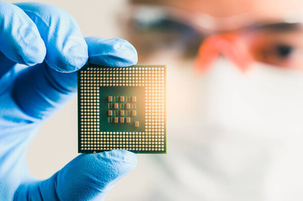 The technician is putting the CPU on the socket of the computer motherboard.