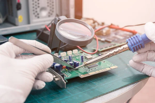 The abstract image of the technician repairing computer equipment by soldering. the concept of computer hardware, repairing, upgrade and technology.