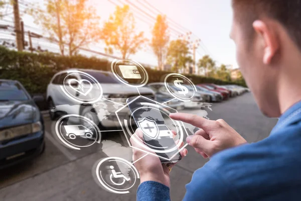 İş adamının soyut görüntüsü, akıllı telefonundaki holograma ve bulanık araba kazasına işaret ediyor. Şeylerin iletişim, ağ, sigorta, finans ve internet kavramı.