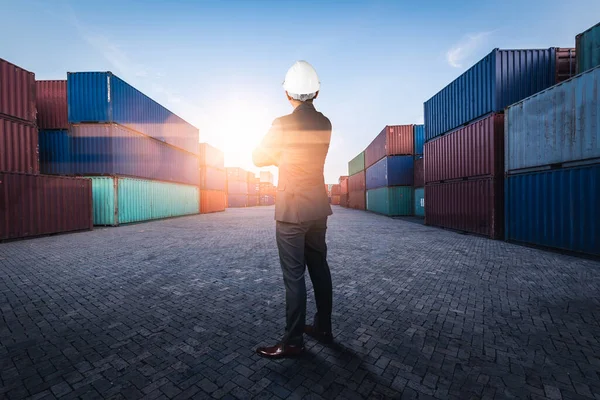 The abstract image of the engineer standing in shipping container yard and copy space. the concept of engineering, shipping, shipyard, business and transportation.