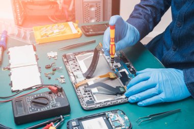 Asyalı teknisyenin laboratuvarda tornavidayla tablet tamir ederken ki soyut görüntüsü. bilgisayar donanımı, cep telefonu, elektronik, onarım, güncelleme ve teknoloji kavramı.