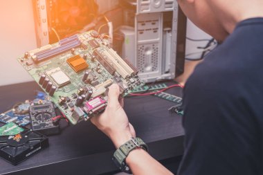 Teknisyenin soyut görüntüsü tamir için modası geçmiş bir bilgisayar ana tahtasını tutuyor. Bilgisayar donanımı, onarım, güncelleme ve teknoloji kavramı