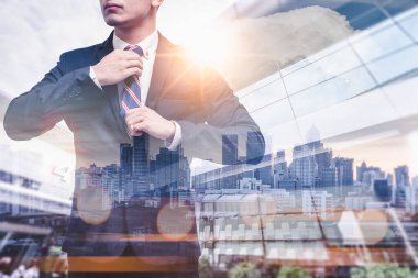 Gündoğumu sırasında kentin görüntüsüyle örtüşen iş adamının çifte pozlama görüntüsü. Modern hayat, iş, şehir hayatı ve internet kavramı..