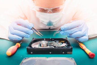 Sabit diskin içinde tornavida tarafından tamir edilen teknisyenin soyut görüntüsü. Veri, donanım, teknisyen ve teknoloji kavramı