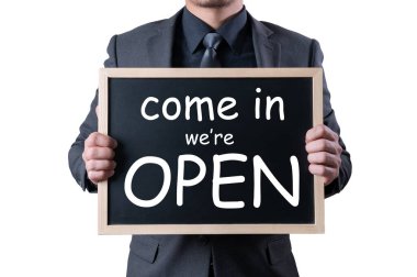 İş adamı bir açılış levhası tutuyor. Yeni normal, yeniden açılma, ekonomik ve iş dünyası kavramı.