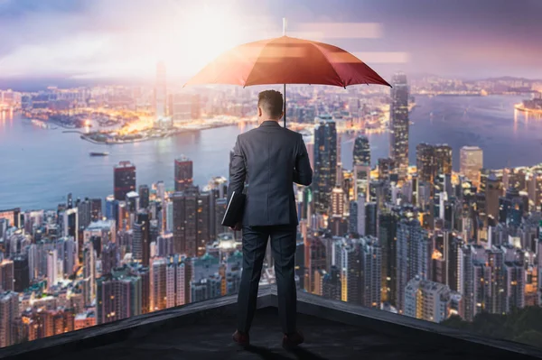 ビジネスマンの二重露光イメージが街並のイメージで日の出オーバーレイ中に傘を広げています 現代生活 ビジネス 保護の概念 ストックフォト