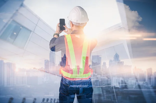 Gündoğumu sırasında kentin görüntüsüyle örtüşen mühendisin çift pozlama görüntüsü. Mühendislik, inşaat, şehir hayatı ve gelecek kavramı..