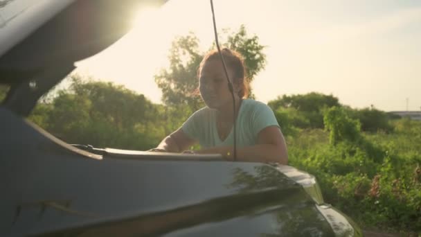 Ασιάτισσα Γυναίκα Ανοιχτό Αυτοκίνητο Κουκούλα Και Προσπαθήσουμε Βρούμε Σπασμένα Μέρος — Αρχείο Βίντεο