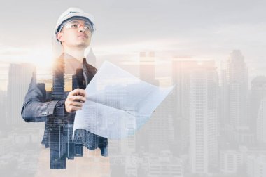 Gündoğumu sırasında kentin görüntüsüyle örtüşen mühendisin çift pozlama görüntüsü. Mühendislik, inşaat, şehir hayatı ve gelecek kavramı..