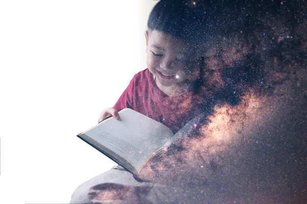 天の川銀河のイメージで本のオーバーレイを読んでいる少年の二重露光画像 想像力技術未来ゲームという概念は ロイヤリティフリーのストック画像