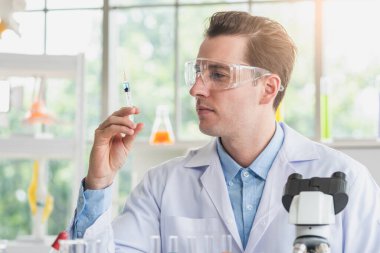 Bilim adamı laboratuvarda bir anti-koronavirüs aşısı deneyi yürütüyor. Coronavirus, anti-virüs, aşılar ve ilaçlar konsepti.