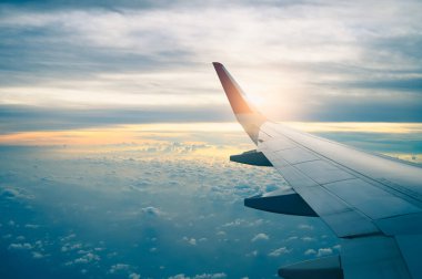 Uçağın penceresinden ve alacakaranlık gökyüzünden görüntü. Seyahat, tatil, ulaşım ve iş konsepti.