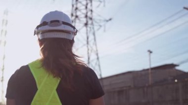 Mühendis, Sinrise sırasında yüksek voltaj kulesini inceliyor. mühendislik, endüstri, inşaat ve teknoloji kavramı.