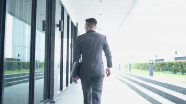 Ofiste yürüyen işadamının 4K görüntüsü. iş, ofis, yönetim ve girişimci kavramı. 