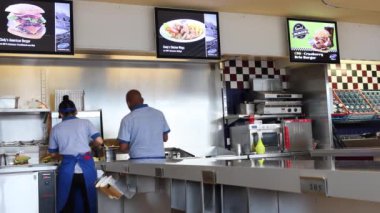 Deitingen, İsviçre - 10 Temmuz 2020: Cindy 'nin fast food restoranında çalışanlar hamburger ve diğer fast food hazırlıyorlar