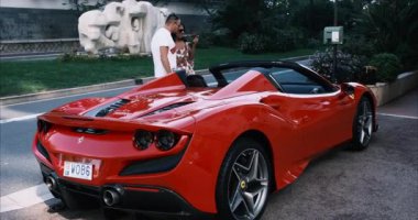 Monte Carlo, Monako - 7 Temmuz 2020: Ferrari süper spor arabalarının yanında kadın ve erkek