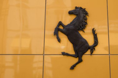 Monte Carlo, Monaco - 4 Temmuz 2020: Sarı arkaplandaki at - Ferrari markasının amblemi