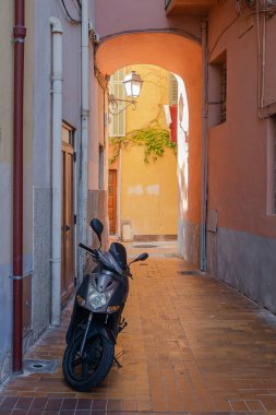 Menton, Fransa - 2 Temmuz 2020: Eski Menton kasabasının dar sokaklarında scooter