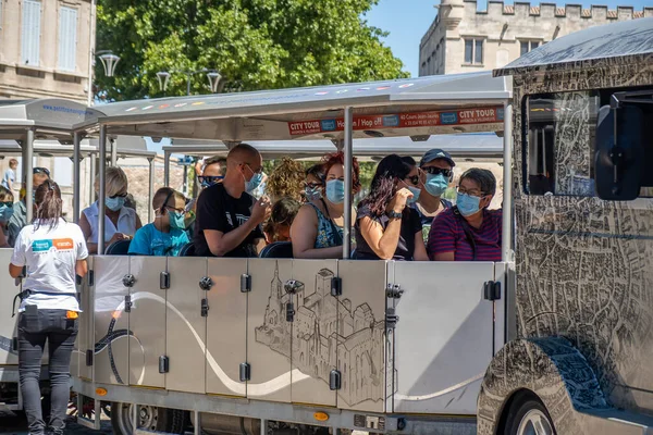 Avignon, Fransa - 7 Temmuz 2020: Turistler Avignon 'daki bir turizm treninde hijyen maskesi takıyorlar