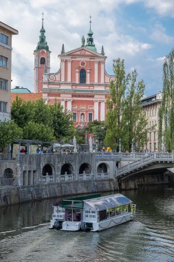 Ljubljana, Slovenya - 13 Ağustos 2020: Tromostovje 'deki ünlü Frankkan kilisesi ve Ljubljanica nehri.