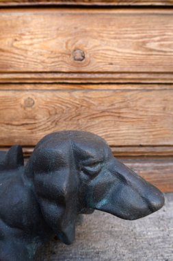 Mustair, İsviçre - 8 Eylül 2020: Ahşap bir evin önündeki bir köpeğin bronz heykeli