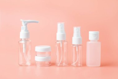 Bej turuncu arka planda, boş seyahat eden kadınlar için tuvalet malzemeleri seti. Uçak bagaj şişesi boyutu onaylandı. Güzellik sosyal medyası için metin alanı ile izole edilmiş