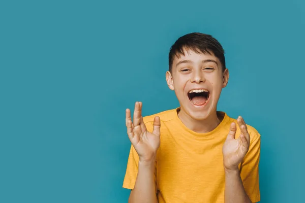 Vay canına, bu harika. Sarı tişörtlü heyecanlı genç çocuk geniş ağızlı ve mutlu yüzlü yüksek sesle bağırıyor, ellerini çırpıyor, koronavirüs salgını sırasında doktorlar için şükrediyor.. 
