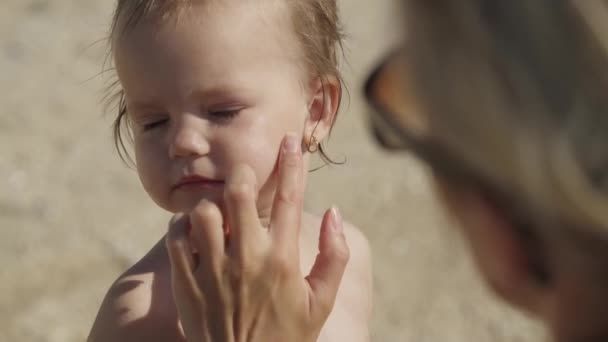 Moeder smelt haar twee jaar oude dochter met zonnebrandcrème — Stockvideo