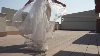 Peignoir giymiş güzel bir gelin terasta yürüyor. Güzel iç çamaşırlı kız, rüzgar elbiseyi uçuruyor..