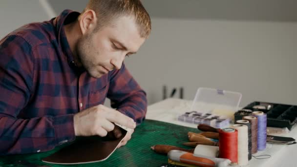 A craftsman sanding a piece of leather for a travel case. The full cycle of production traveled a case of genuine leather. Handmade. — Stock Video