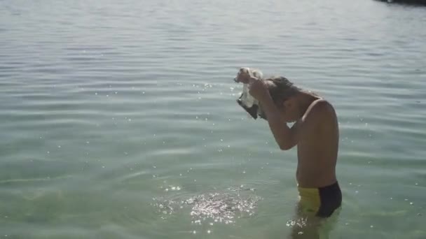 Der Teenager trägt eine Schwimmmaske und taucht ins Wasser. — Stockvideo