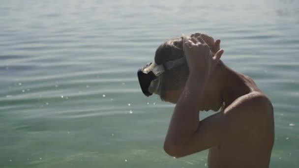 A tinédzser úszó maszkot visel és belemerül a vízbe.. — Stock videók