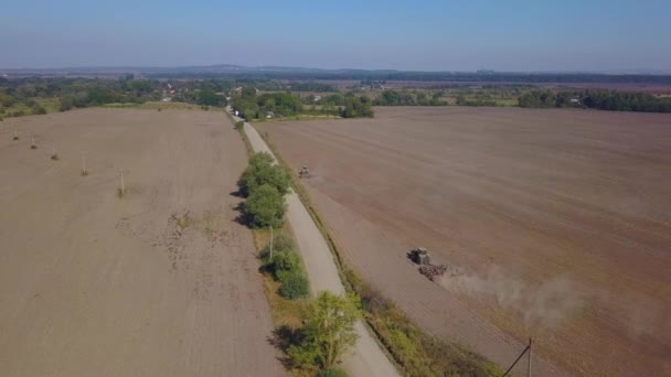 Aerial view. Tractor cultivates agricultural land. — Stock Video