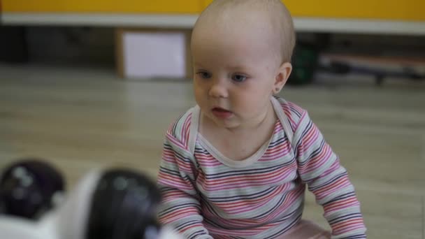 La bambina guarda attentamente il robot giocattolo e balla con lui. Tecnologie robotiche moderne — Video Stock