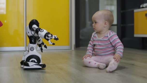 The little girl carefully looks at the toy robot and dances with him. Modern Robotic Technologies — Stock Video