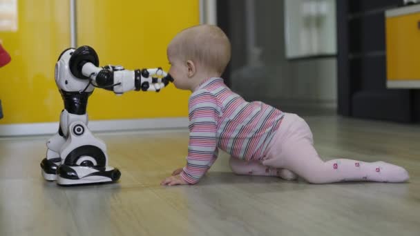 女の子はおもちゃのロボットを注意深く見て、彼と踊ります。現代のロボット技術 — ストック動画