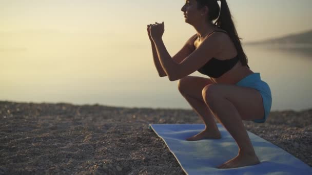 Mooie vrouw traint op het strand. Zee, zonsopgang, strand, training, slow motion — Stockvideo