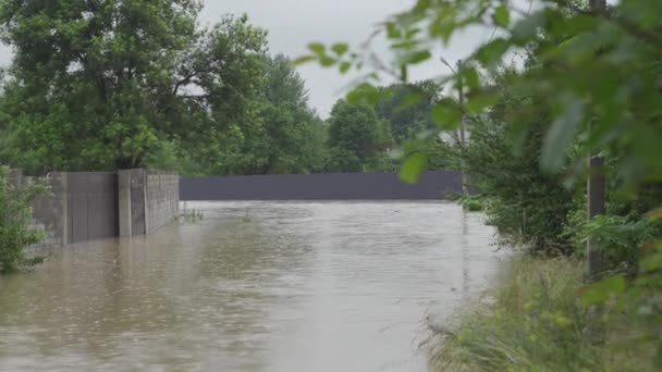 Überflutete Straße bei Überschwemmungen. Wasser überflutete die Straße und den Zaun eines Privathauses. Es regnet und der Wasserspiegel steigt. Limnitsa-Fluss Ukraine. — Stockvideo