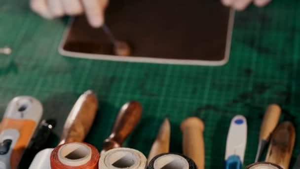 The master applies a softening cream to the skin. The process of manufacturing a travel case made of genuine leather. Handmade. Macro shooting. — Stock Video