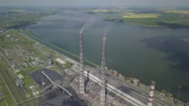 Suni bir su deposunun arka planındaki termik santral. Drone 'un videosu. Fosil yakıtlardan elektrik üretimi. Kömür ve yakıt yanması. Burshtyn Ukrayna.