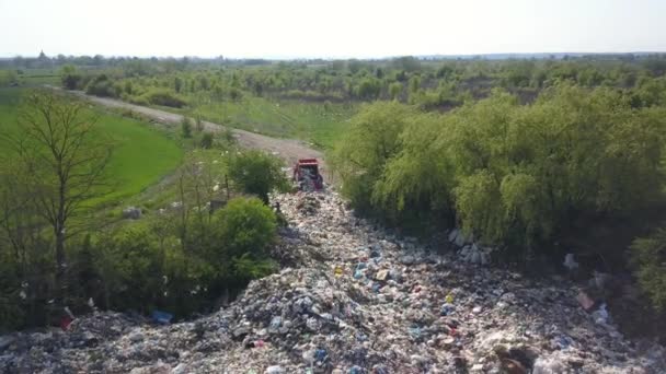 Een vuilniswagen arriveert op een natuurlijke stortplaats. Mensen dumpen afval bij de ingang. Luchtopname. — Stockvideo