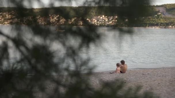 男の子と女の子はビーチに座っている。兄と妹は海で休んでいる。感情愛優しさ, — ストック動画