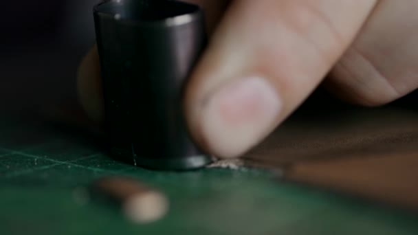 Le processus de fabrication d'un portefeuille en cuir fait main. L'artisan a coupé un morceau de cuir. Maroquinerie artisanale. Macro. — Video