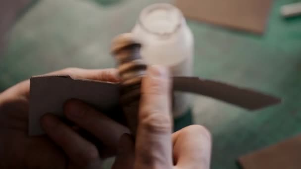 Le processus de fabrication d'un portefeuille en cuir fait main. Un artisan broyant un morceau de cuir. Maroquinerie artisanale. Macro. — Video