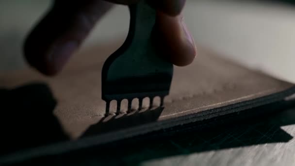 The process of manufacturing a leather wallet handmade. The artisan punches holes for flashing. Handmade leather goods. Macro. — Stock Video